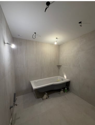 Salle de bain carrelée en grand format effet travertin avec baignoire encastrée, chantier RJM Rénovation à Fréjus