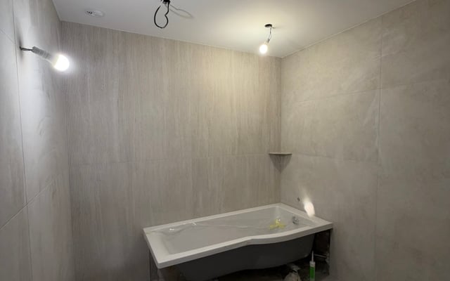 Salle de bain carrelée en grand format effet travertin avec baignoire, chantier RJM à Fréjus