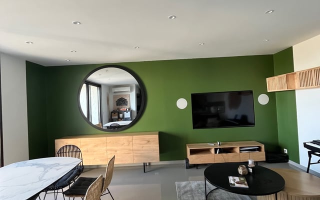 Mur d'accent vert profond peint dans un salon par RJM Rénovation