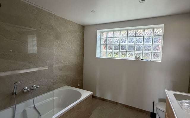 Salle de bain carrelée dans les tons beige par RJM Rénovation