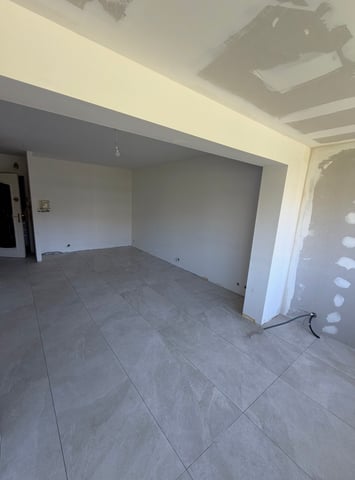 Séjour carrelé en grand format effet pierre grise après ragréage, chantier RJM Rénovation dans le Var