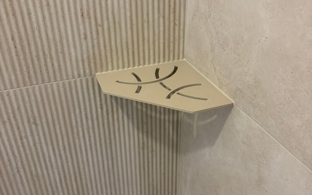 Tablette d'angle intégrée dans une douche carrelée effet travertin par RJM Rénovation